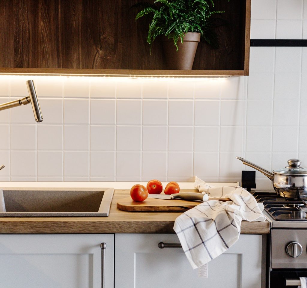 cooking-food-on-modern-kitchen-with-steel-oven-pots-knife-on-wooden-cutting-board.jpg